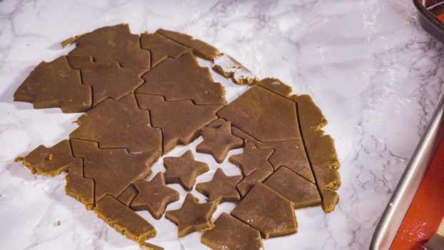 Step by step. Cutting out shapes with Christmas cookies cutter from gingerbread cookie dough.