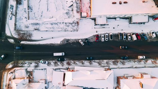 Top down aerial overhead perspective of street. Hyperlapse of car traffic on road passing through town at winter sunny evening, 4k footage