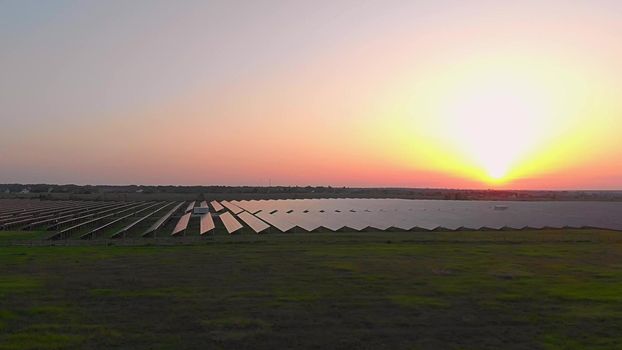 Large solar panels at a solar farm at summer sunset. Solar cell power plants. footage video 4k, aerial drone view