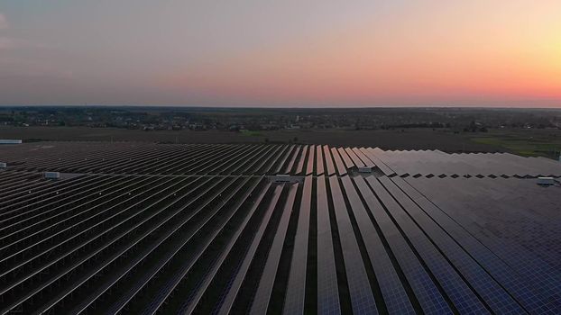 Large solar panels at a solar farm at summer sunset. Solar cell power plants. footage video 4k, aerial drone view