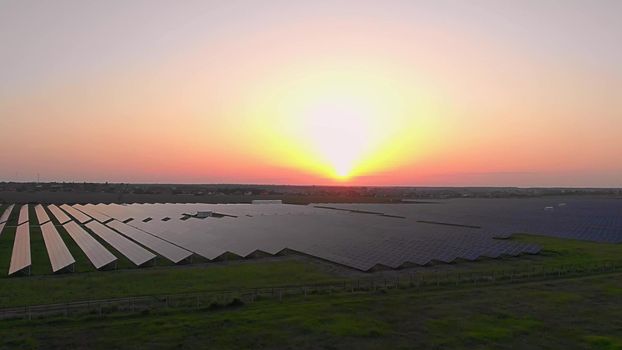 Large solar panels at a solar farm at summer sunset. Solar cell power plants. footage video 4k, aerial drone view