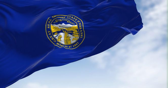 The Nebraska state flag waving in the wind. Nebraska is a state in the Midwestern region of the United States.