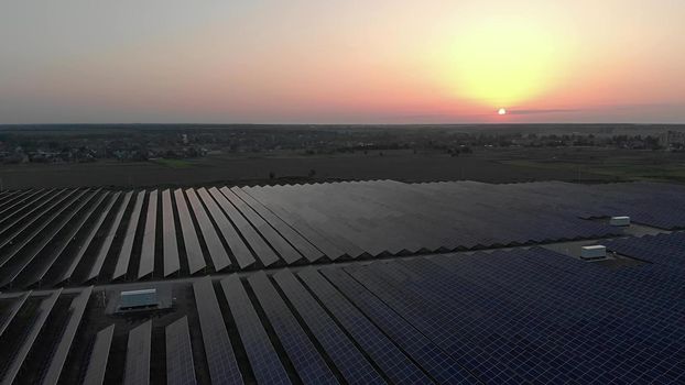 Large solar panels at a solar farm at summer sunset. Solar cell power plants. footage video 4k, aerial drone view