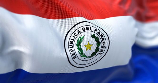 Close-up view of the Paraguay national flag waving in the wind. Republic of Paraguay is a landlocked country in South America. Fabric textured background. Selective focus