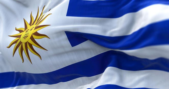 Close-up view of Uruguay national flag waving in the wind. The Oriental Republic of Uruguay is a country in South America. Fabric textured background. Selective focus