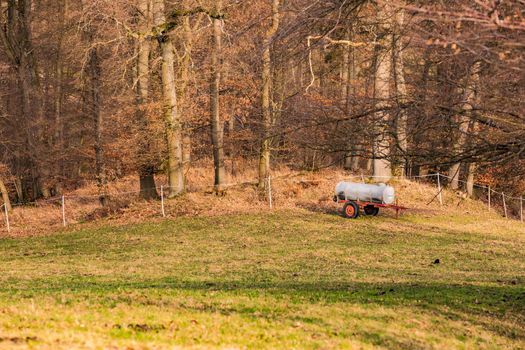 A mobile barrel truck secures water supply for livestock on pasture in rural Germany