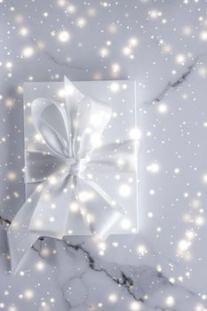 New Years Eve celebration, winter decoration and Valentines Day presents concept - Luxury holiday gifts with white silk bow and ribbons on marble background, Christmas time surprise