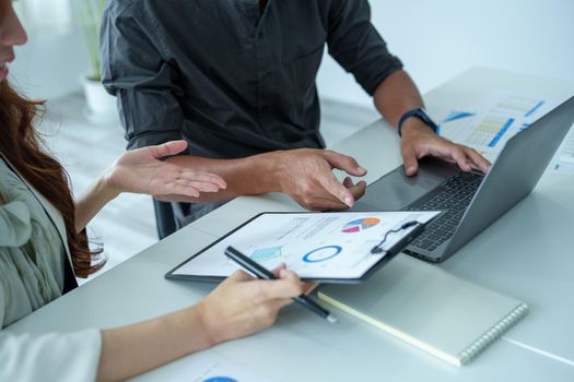A portrait of a female marketer and a male salesperson discussing how to increase sales by investing in new products to expand marketing using documents and computers in working, new idea product.