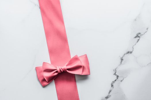 Birthday, wedding and girly branding concept - Coral silk ribbon and bow on marble background, girl baby shower present and glamour fashion gift decor for luxury beauty brand, holiday flatlay design