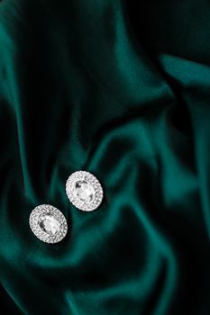 Jewellery brand, elegant fashion and bridal luxe gift concept - Luxury diamond earrings on dark emerald green silk, holiday glamour jewelery present