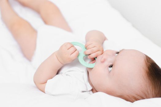 A baby with a teether on a white background . Teething. Children's article. Copy space