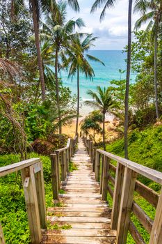 Wood stairs steps down to the Nai Thon Naithon Beach bay and landscape panorama a beautiful dream beach with turquoise clear water and waves in Sakhu Thalang on Phuket island Thailand.