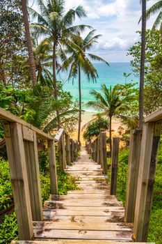 Wood stairs steps down to the Nai Thon Naithon Beach bay and landscape panorama a beautiful dream beach with turquoise clear water and waves in Sakhu Thalang on Phuket island Thailand.