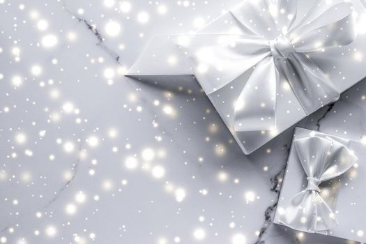 New Years Eve celebration, winter decoration and Valentines Day presents concept - Luxury holiday gifts with white silk bow and ribbons on marble background, Christmas time surprise