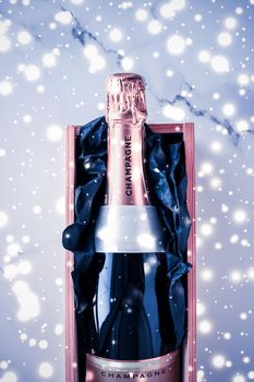Celebration, drinks and branding concept - Champagne bottle and gift box on blue holiday glitter, New Years, Christmas, Valentines Day, winter present and luxury product packaging for beverage brand