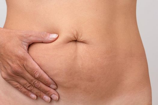 Cropped woman hand on right side of stomach to show pain or symptom there