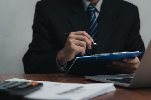 businessman holding pen signature document on clipboard at desk. Business information insurance lawyer and job concept.