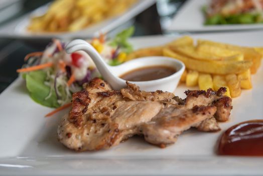 Steak chicken and salad vegetable in dish on table.