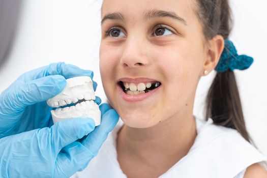 little girl with plaster cast of teeth and with the metal apparatus on the teeth