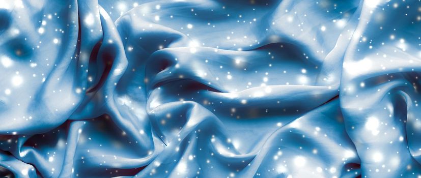 Winter fashion, shiny fabric and glamour style concept - Magic holiday blue soft silk flatlay background texture with glowing snow, luxury beauty abstract backdrop