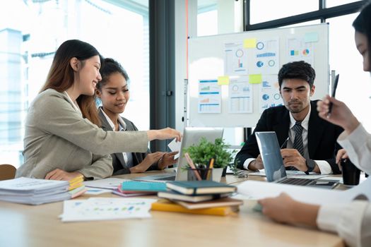 business team people and female leader boss discuss financial result review paperwork share ideas brainstorm collaborate work in teamwork at group briefing table.