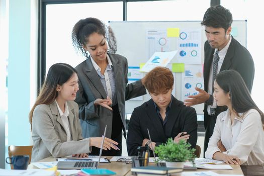 Asian business woman leader workers a paper business plan in a group meeting. Emphasis on female mentor teachers Train a variety of employees in corporate