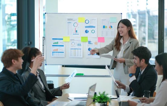Female Operations Manager Holds Meeting Presentation for a Team of Economists. Asian Woman Uses Digital Whiteboard with Growth Analysis, Charts, Statistics and Data. People Work in Business Office..