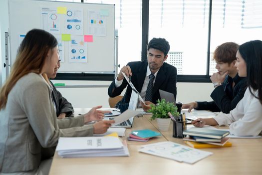 business team people and female leader boss discuss financial result review paperwork share ideas brainstorm collaborate work in teamwork at group briefing table.