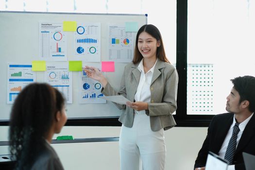 Female Operations Manager Holds Meeting Presentation for a Team of Economists. Asian Woman Uses Digital Whiteboard with Growth Analysis, Charts, Statistics and Data. People Work in Business Office..