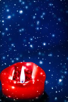 Happy holidays, greeting card and winter season concept - Red holiday candle on blue sparkling snowing background, luxury branding design for Christmas, New Years Eve and Valentines Day