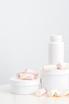 Cosmetic skincare packaging. Beauty product on white background. White jars with marshmallows on the white table