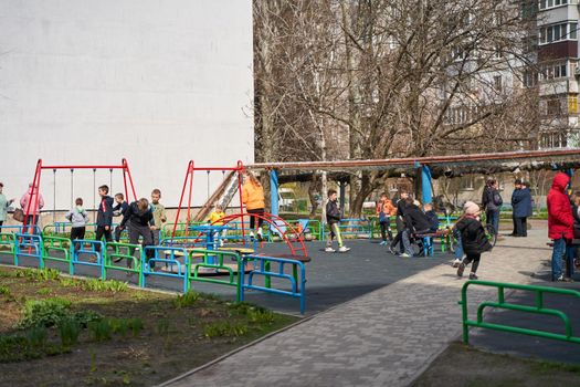 Crowded playground, kids enjoy spring days. Dnipro, Ukraine - 04.19.2022