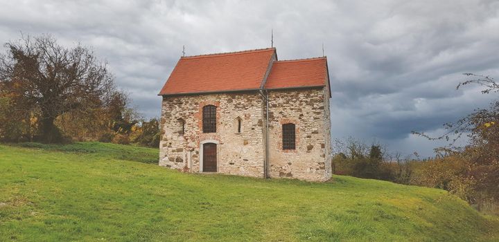 house on the hill in the middle of the forest with dramatic clouds. High quality photo