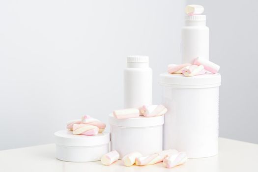 Cosmetic skincare packaging. Beauty product on white background. White jars with marshmallows on the white table