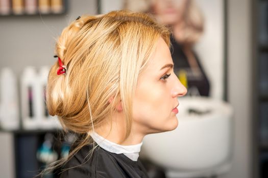 Gorgeous profile of caucasian beauty blonde woman with beautiful hairstyle over hair salon background