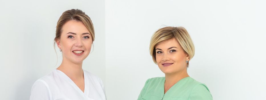 Portrait of two cosmeticians smiling against a white background. Copy space