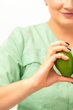 Female nutritionist doctor holding organic avocado fruit. Healthy lifestyle concept