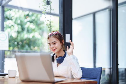 Portrait of a beautiful woman using a computer and a notebook during a video conference