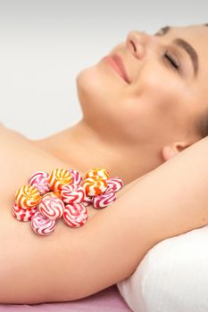 Colored round candies under the female armpit, close up, depilation armpit concept