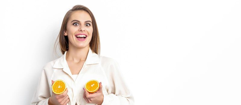 Joyful attractive young woman having two pieces of orange isolated on white background with copy space