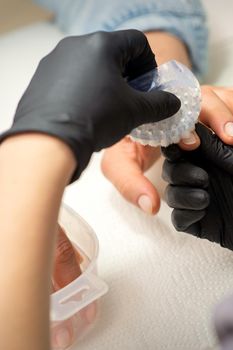 Hands of the manicure master removing dust from nails with a brush cleaning nails in nail salon