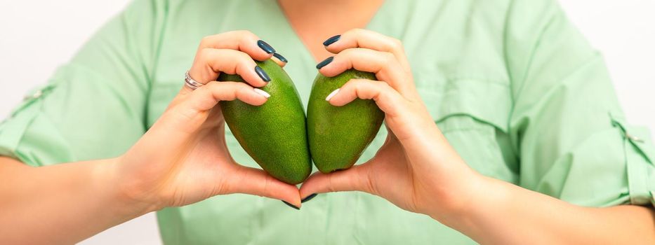 Female nutritionist doctor holding organic avocado fruit. Healthy lifestyle concept