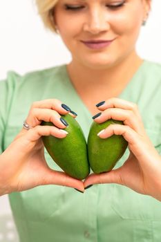 Female nutritionist doctor holding organic avocado fruit. Healthy lifestyle concept