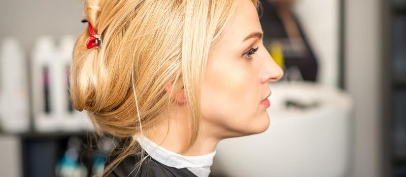 Gorgeous profile of caucasian beauty blonde woman with beautiful hairstyle over hair salon background