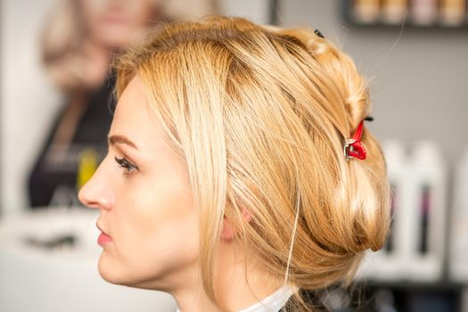 Gorgeous profile of caucasian beauty blonde woman with beautiful hairstyle over hair salon background