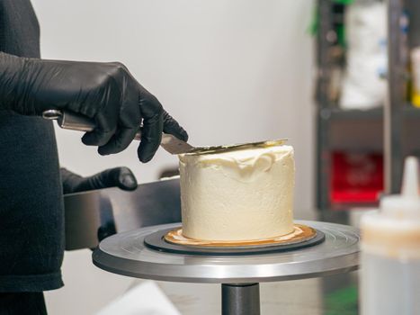 professional baker decorating a chocolate and cream cake with salty caramel