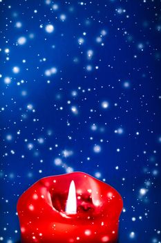 Happy holidays, greeting card and winter season concept - Red holiday candle on blue sparkling snowing background, luxury branding design for Christmas, New Years Eve and Valentines Day