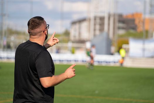 Football coach controlling the game from the edge of the field.