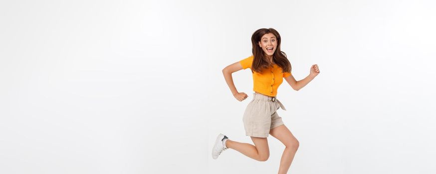 Portrait of a joyful woman jumping in the studio with happy feeling, isolated on white background, 20-28 year old