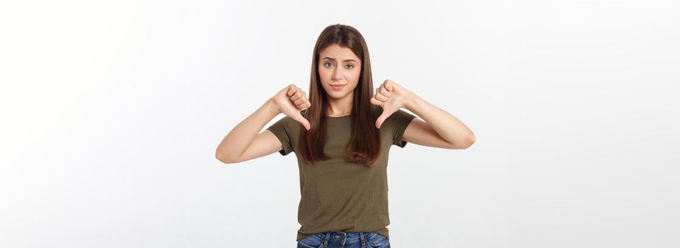 Image of resentful woman with long dark hair showing thumbs down isolated over gray background